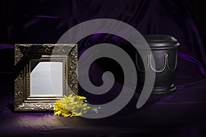 Black urn with yellow chrysanthemum and blank golden morning frame on deep purple background