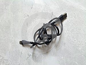 black USB cable roll on patterned marble floor