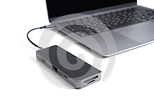 Black usb-hub connected to a modern laptop on white