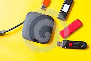 Black USB HUB with usb stick flash drives on yellow background. Top view