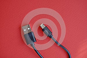 Black USB PC cable on red background