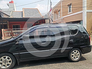 Black van car parked in front of the houses