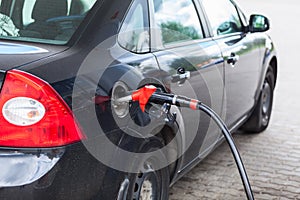 Black vehicle refueling with petrol