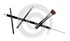 Black velvet ribbon and three makeup brushes on white background