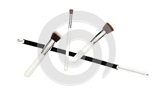 Black velvet ribbon and three makeup brushes on white background