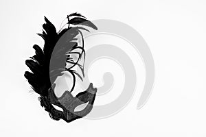 Black Venetian carnival mask isolated on white background, top view flat lay.