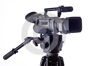 Black Video camera mounted on tripod against white