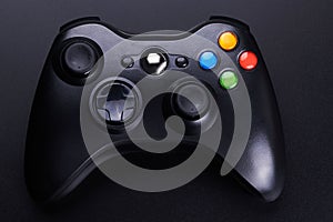 Black video game controller, joystick for game console isolated on black background
