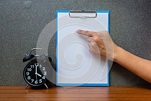 Black vintage alarm clock with clipboard and blank white paper, copy space for add your text, work on time or over time and