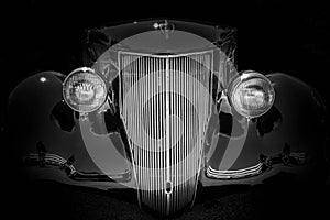 BLACK VINTAGE CAR FRONT ON BLACK BACKGROUND