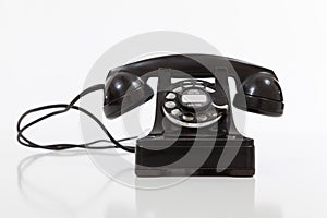 Black, vintage rotary phone on white
