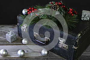 Black vintage suitcase with Christmas holly on top