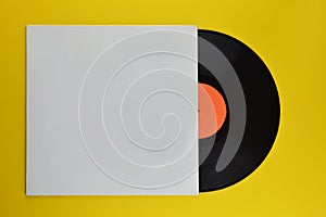 Black vinyl record halfway out of white cover photo