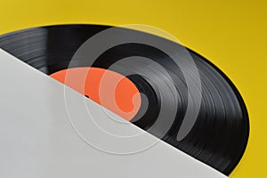 Black vinyl record halfway out of white cover photo