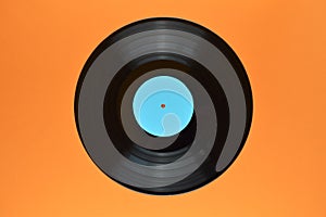 Black vinyl record on orange background