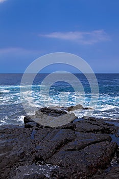 Black volcanic rocks on ocean shore