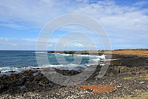 Black, volcanic rocky shoreline against the deep blue waters of the Pacific Ocean in Hawaii