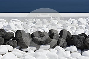 Black volcanic stones over white. Decoration detail at Santorini island