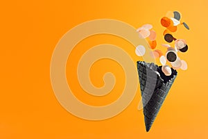 Black waffle ice-cream cone with multicolored confetti. Halloween holiday concept, Black Friday banner