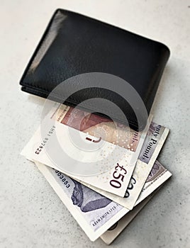 Black wallet with British pounds
