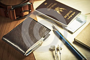 Black wallet, passport, money, notebook and belt.