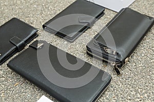 Black wallet purse on pavement. White package with no inscriptions. Leatherette wallet