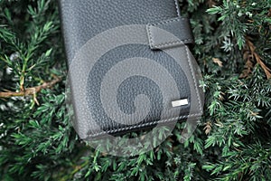 Black wallet purse on pavement. White package with no inscriptions. Leatherette wallet