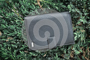Black wallet purse on pavement. White package with no inscriptions. Leatherette wallet