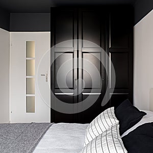 Black wardrobe in simple bedroom