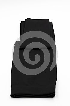 Black warm women`s leggings, thermal underwear lie neatly folded isolated on a white background