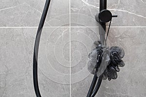 Black washcloth in the shower in modern gray bathroom