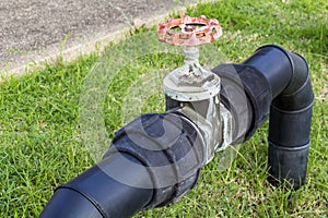 Black water pipes joined with rusty red valves for safety and cl