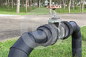 Black water pipes joined with rusty red valves for safety and clean watering system in modern building construction and industrial