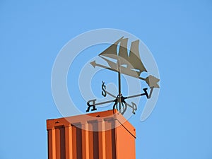 Black weather vane on home roof, Lithuania