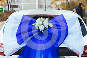A black wedding car decorated with roses. Luxury wedding car decorated with flowers and ribbons