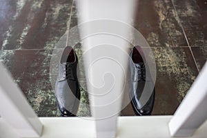 Black wedding shoes stand on a vintage floor