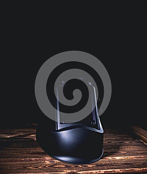 Black welding mask on a wooden background. A studio photo with hard lighting