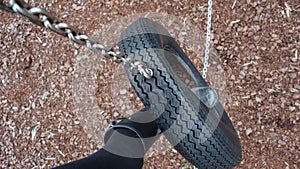 Black welly boot in a tyre swing