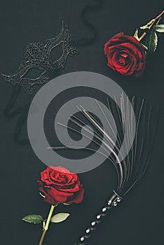 Black whip and lacy mask with rose flowers