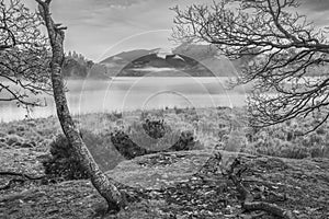 Black and white Absolutely stunning vibrant Autumn sunrise landscape image looking from Manesty Park in Lake Distict towards