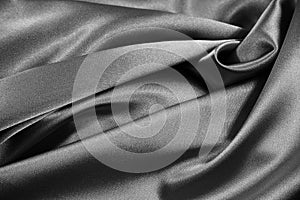 Black white abstract background. Beautiful folds on shiny fabric. Silk satin texture background. Elegant silver background.