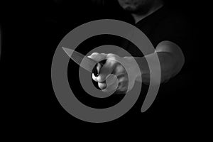 Black and White Adult Man Holding Sharp Knife in the Shadow. Concept Picture of Murderer, Killer, Assasin, Robber or Theft