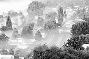 Black and white aerial foggy landscape of small town USA in countryside Colfax, Eastern Washington