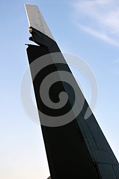 Black and white airplane wing at blue sky with clouds background.