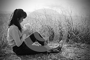 Black and white of alone Woman sitting and hug teddy bear