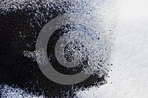 Black and white texture from the ashes of a fire and snow