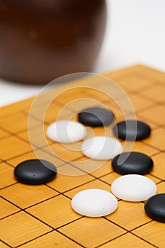 Black and white baduk stones on wood board