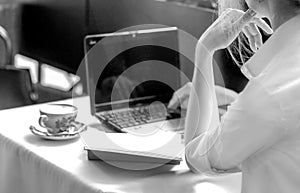 Black and white banner with a woman working on a laptop in a summer cafe