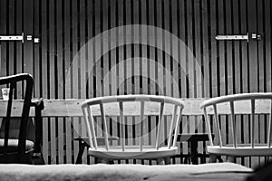 Black and white bar chairs in front of a barndoor wooden styled wall photo