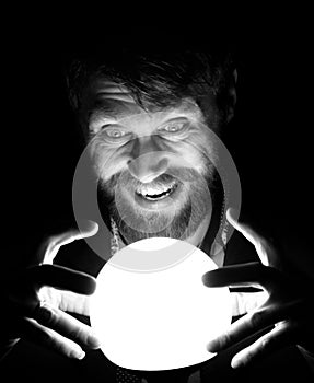 Black and white, bearded man in the dark, holding in front of a lamp, expresses different emotions